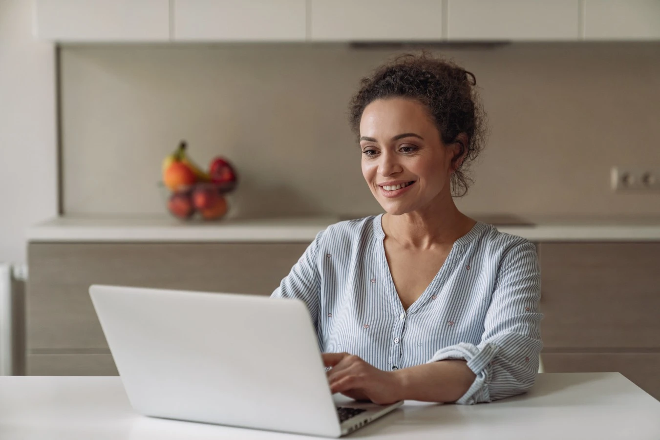 Happy professional woman making NDIS referral on laptop at home
